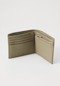Portefeuille en cuir vert olive, comportant quatre emplacements pour cartes, une poche à pièces zippée, et une finition texturée, avec un logo embossé à l'avant.
