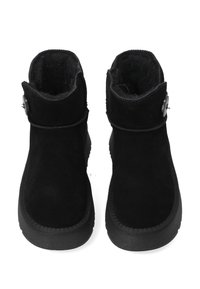 Czarne zamszowe botki za kostkę z zaokrąglonym noskiem, miękką wewnętrzną wyściółką i ozdobnym guzikiem po boku. Płaskie, teksturowane gumowe podeszwy.