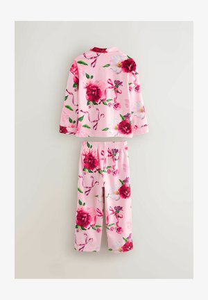 Blumen-Pyjama-Set mit langärmligem Oberteil und Hose aus pinkem Stoff. Es zeichnet sich durch große rote und pinke Blumenmuster mit grünen Blättern und Bändern aus.