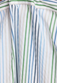 Tissu rayé présentant des lignes verticales dans des nuances de bleu, vert, gris et blanc. Coton léger avec une texture lisse.