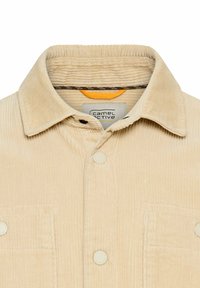 Beige corduroy shirt met een kraag, knoopsluiting aan de voorkant en twee borstzakken. Gelaagd stof met subtiele verticale strepen.