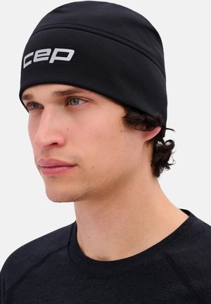 Berretto nero con finitura testurizzata e logo bianco "CEP" sulla parte anteriore. Il design presenta una vestibilità aderente e cuciture lisce.