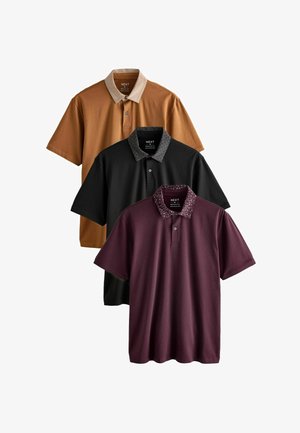 Kolm keskmise suurusega meeste polo särki, pruun, must ja burgundia, igaühel kontrastsete mustriga kraedega, asetatud üksteise peale.