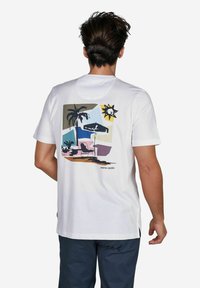 Weißes Baumwoll-T-Shirt mit einem bunten Grafikdesign auf der Rückseite, das Palmen, eine Sonne und Strandelemente darstellt; Etikett trägt "pierre cardin."