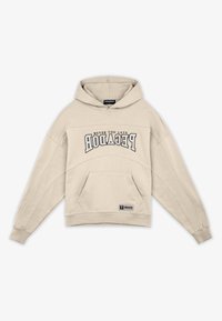 Felpa beige con tasca a marsupio, caratterizzata da un audace design di testo grafico e polsini e orlo a coste. Realizzata in morbido tessuto.