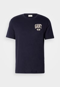 T-shirt en coton bleu marine avec col rond, arborant un logo "GANT 49" imprimé de couleur claire sur la poitrine gauche. Manches courtes, coupe classique.