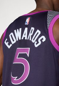 Košarkaška majica u crnoj boji s ljubičastim detaljima. Ima ime igrača "EDWARDS" i broj "5" u bijeloj boji. Tekstura tkanine s sivim uzorkom na ramenu.