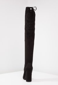 Schwarze Wildleder-Stiefel über das Knie mit passgenauen Design, runder Zehenpartie und Blockabsatz. Mit einem Schnürdetail an der Oberseite zur Anpassung.