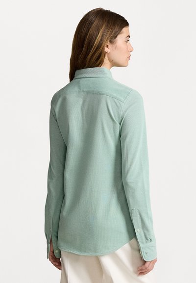 Camicia a maniche lunghe verde chiaro con colletto, polsini abbottonati e orlo curvo. Tessuto testurizzato con un sottile motivo mélange.