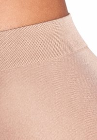 Jasnoróżowe legginsy bez szwów z teksturowanym, żeberkowym pasem i gładkim materiałem o lekkim połysku.