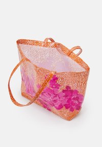 Sac fourre-tout transparent avec un motif floral orange et rose, doté de poignées fines et d'une surface texturée avec un motif à pois.
