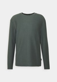 Koszulka z długim rękawem i prążkowanym, okrągłym dekoltem w ciemnozielonym kolorze. Miękka w dotyku, o luźnym kroju. Posiada małą metkę marki przy lamówce.