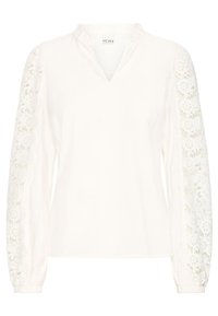 Blouse blanche à col en V et manches longues avec des détails en dentelle complexes. Tissu doux avec une coupe décontractée et des poignets élastiqués.