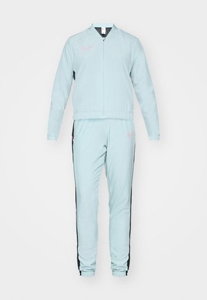 Light blue track suit with a zippered jacket and elastic cuffs. Pink logo on the chest and side stripes on the pants. Smooth, breathable fabric.