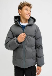 Giacca imbottita grigia con cappuccio, chiusura frontale con cerniera e polsini elastici. Presenta una texture liscia con una finitura leggermente lucida.