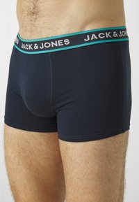 Dunkelblaue Boxershorts aus weichem Stoff, mit einem kontrastierenden elfenbein- und schwarzen elastischen Bund mit "JACK & JONES"-Branding.