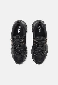 Baskets de sport noires avec un dessus en mesh texturé, semelle en caoutchouc épais et pointe renforcée. Comprend des lacets noirs et des accents en métal argenté.