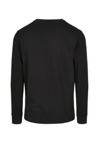 Melns džemperis ar apaļu kakla izgriezumu, garām piedurknēm un ribotas aprocēm un apakšmalu. Gluda tekstūra un vienkāršs dizains, bez redzamām rotājumām.