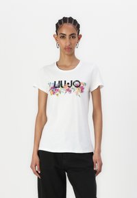 T-shirt en coton blanc avec un imprimé floral multicolore et le lettrage "LIU JO" sur la poitrine ; manches courtes, col rond.