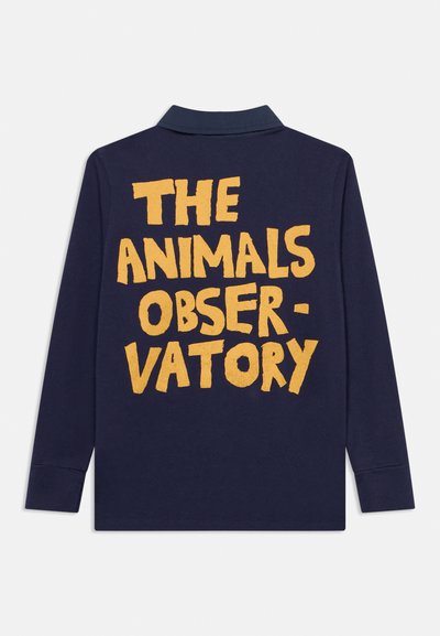 Chemise à manches longues bleu marine avec col, comportant un grand texte jaune "THE ANIMALS OBSERVATORY" au dos.