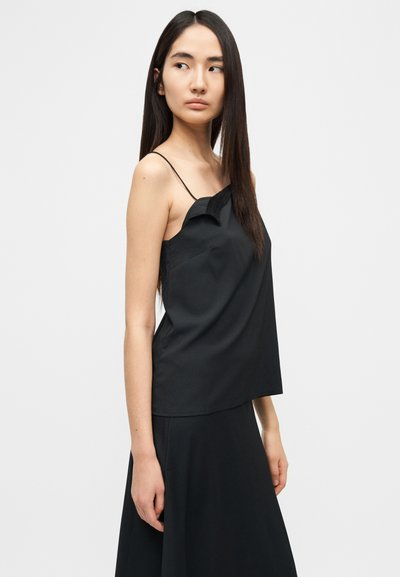 Μαύρο αμάνικο μπλουζάκι με ασύμμετρο σχέδιο, απαλής υφής, λεπτές τιράντες και διακριτικές λεπτομέρειες στη λαιμόκοψη. Λείο, ρέον ύφασμα.