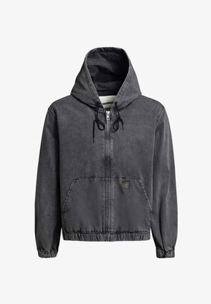 Tamsiai pilkas užsegamas džemperis su priekinėmis kišenėmis, reguliuojamu raišteliu gaubtu, elastinėmis rankogaliais ir mažu kvadrato formos pledu ant kišenės.