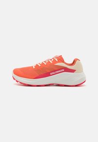 Salomon running shoe featuring a bright orange upper, white midsole, and pink outsole. Textured design with contrasting color accents.