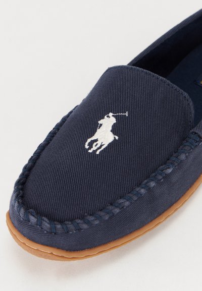 Cipele za slip-on od pomorskog materijala s bijelim vezom logotipa poloa, teksturirana površina i smeđa gumena potplat, sa šavovima uz rub.
