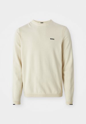 Beige trui gemaakt van zacht materiaal, met een ronde halslijn, lange mouwen, ribgebreide manchetten en een klein zwart "BOSS" logo op de borst.