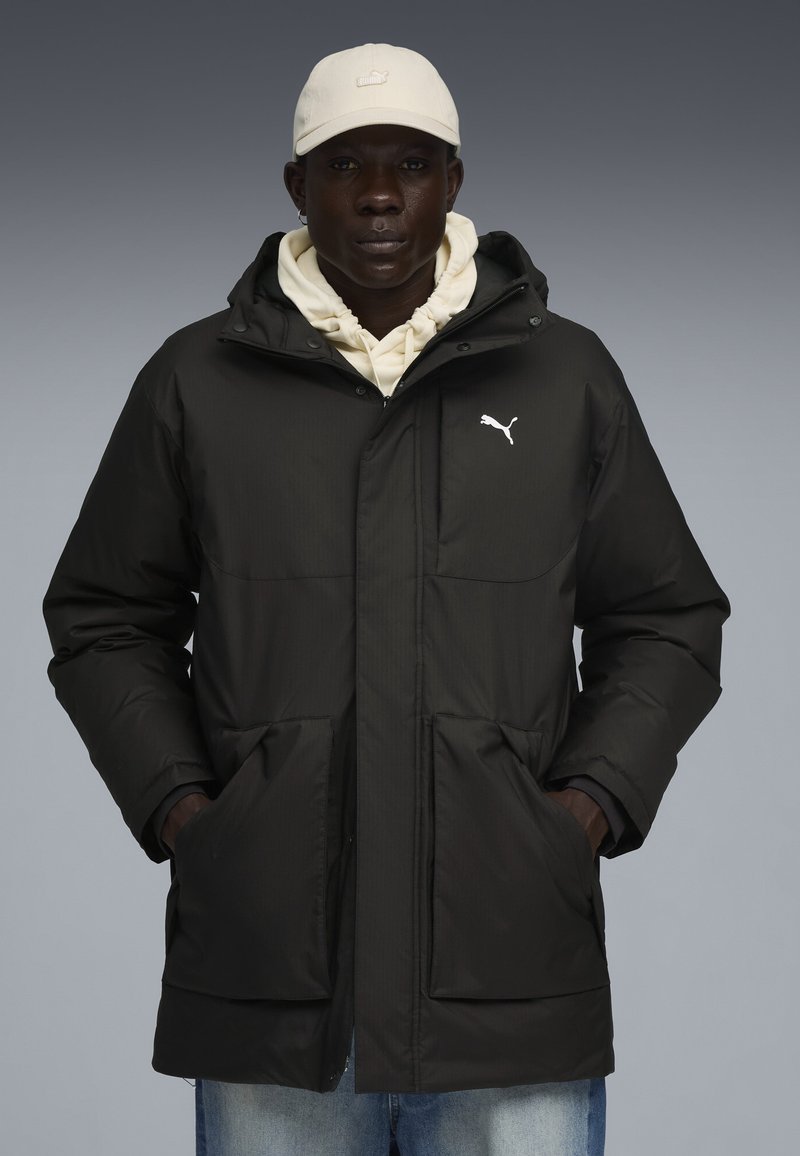 Giacca nera imbottita con due tasche frontali e cappuccio, con logo Puma bianco sul lato sinistro del petto e finitura testurizzata.