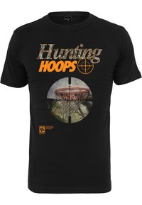 Juodas medvilnės marškinėlis su "Hunting Hoops" užrašu kamufliažo ir oranžine spalvomis, su apvaliu grafiniu pejzegiu, vaizduojančiu krepšinio lanką.