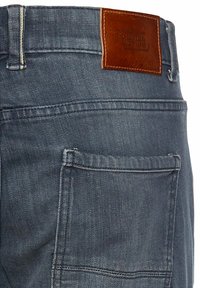 Denimjeans in vervaagd blauw met een leren patch op de achterkant van de tailleband. Bevat een achterzak met stikseldetails.