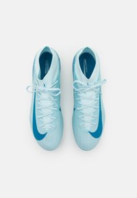 Gaismas zila Nike Mercurial futbola apavu pāris ar tumši zilu Swoosh logotipu un baltām šņorēm, skatīts no augšas uz balta fona.