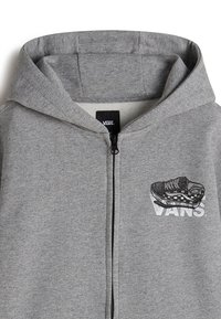 Sudadera con cremallera gris, hecha de una suave mezcla de algodón. Presenta un gráfico de una zapatilla Vans y un logo impresos en negro en el pecho.