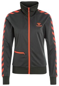 Grå zip-jacka med hög krage, med röda accenter och diagonala ränder på ärmarna. Tillverkad av ett mjukt, lätt material. Fickor med dragkedja ingår.