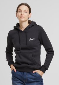 Čierna mikina s kapucňou vyrobená z bavlneného zmesi. Má predné vrecko, šnúrky na sťahovanie a biele vyšívané logo "forest" na hrudi.