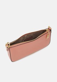 Pieni suorakaiteen muotoinen vaaleanpunainen nahkalaukku, jossa on kultainen vetoketju ja logoriipus, avattuna, joka paljastaa beige kangasvuoren.