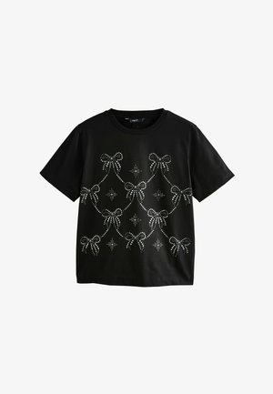 Zwarte t-shirt met korte mouwen, versierd met zilveren strass strikken en sterrenpatronen, gerangschikt in een gedrapeerd ontwerp aan de voorkant.