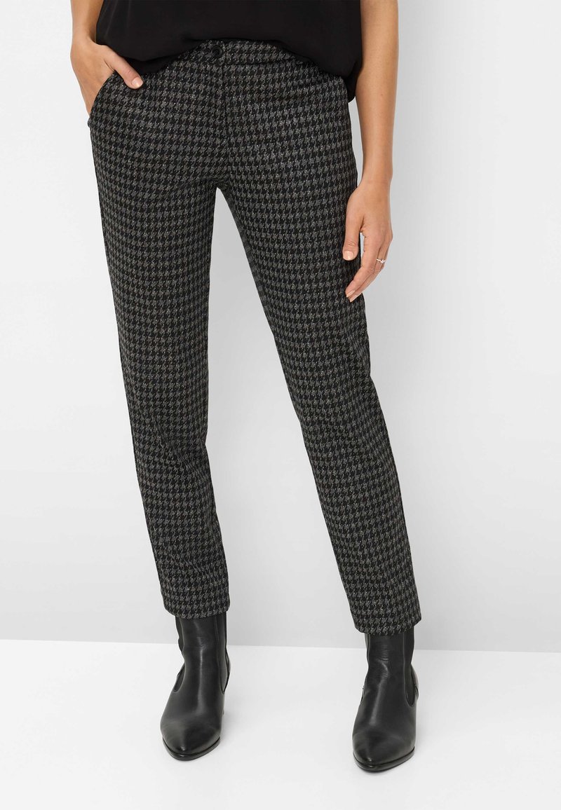 Zwart-grijs houndstooth patroon broek gemaakt van textuurstof, met een slim fit en zijzakken. Gepaard met zwarte enkellaarsjes.