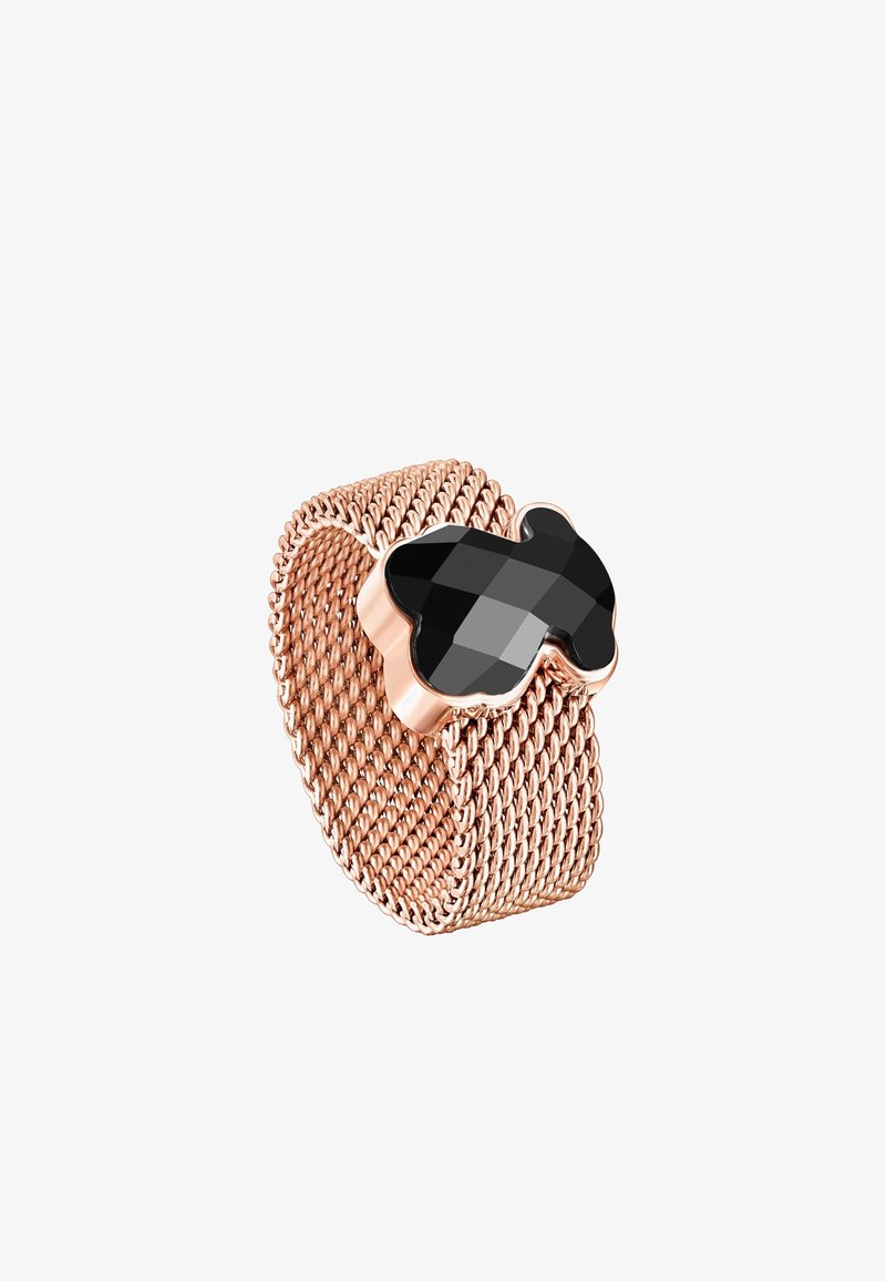 Anillo de malla en oro rosa con un acento en forma de trébol negro y facetado. Textura metálica suave con un intrincado diseño tejido.