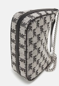 Borsa a tracolla in tela di colore grigio chiaro con motivo logo MK nero, dettagli in pelle nera e tracolla a catena argentata. Forma rettangolare con chiusura a zip.