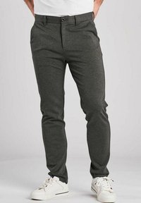 Sive hlače slim fit kroja, ravnega sprednjega dela in z enim gumbom za zapiranje. Narejene iz gladkega materiala, v kombinaciji z belimi supergami za kontrast.