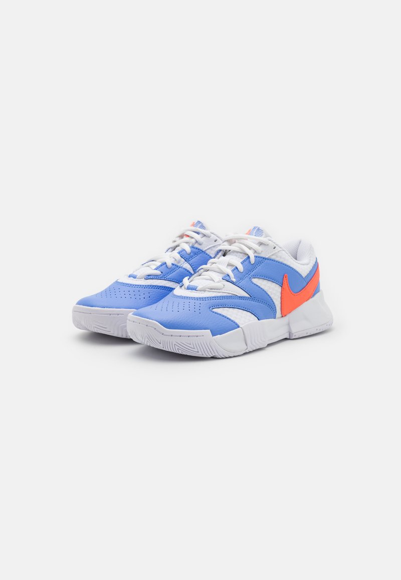 Zapatillas deportivas azules con acentos en blanco y naranja. Presentan una parte superior texturizada, perforaciones para la transpirabilidad y una suela de goma blanca.