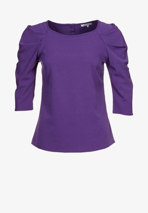 Fioletowa damska bluzka z rękawami o długości do łokcia z bufkami i okrągłym dekoltem, z zamkiem błyskawicznym z tyłu.