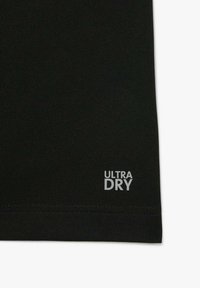 Tissu noir avec une texture tricot serré montrant un petit logo blanc "ULTRA DRY" près du bord inférieur.