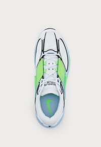 Scarpa sportiva bianca con dettagli neri, pannelli verde vivace, tomaia in mesh e suola azzurra con logo visibile sulla linguetta.