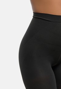 Högmidjade svarta leggings med en texturerad mönster, med slät tyg, sömlös design och en tajt passform runt midjan och höfterna.