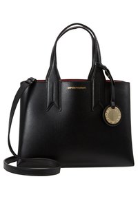 Svart läder tote-väska med strukturerad design, handtag upptill, avtagbar axelrem och en gyllene cirkeltagg med varumärkets logotyp. Röd inredning.