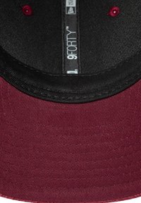 Bordowa czapka z zakrzywionym daszkiem i czarnym spodem. Posiada teksturowany materiał, detale w szyciu oraz wewnętrzną metkę z brandingiem "9FORTY".