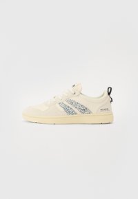Baskets beiges avec une tige souple, ornées d'une bande latérale imprimée léopard et d'une semelle crème. Comprend une languette à l'arrière et un logo de marque.